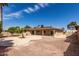 Private backyard with desert landscaping, covered patio, and palm trees at 25620 S Cloverland Dr, Sun Lakes, AZ 85248