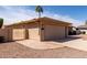 Exterior view of the home, featuring an attached garage, gated side yard, and desert-style landscaping at 25620 S Cloverland Dr, Sun Lakes, AZ 85248