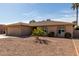 Single-story home with desert landscaping, showcasing arched windows and a classic design at 25620 S Cloverland Dr, Sun Lakes, AZ 85248