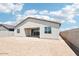 The home's backyard has block wall fencing, a covered patio area, stucco siding and windows looking out onto the spacious dirt lot at 2707 E Abe Truckle Ave, San Tan Valley, AZ 85140