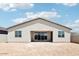 A view of the home's backyard highlighting large windows and sliding glass doors that open up to the spacious dirt-filled backyard at 2707 E Abe Truckle Ave, San Tan Valley, AZ 85140