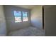 Empty bedroom under construction, with grey walls, a window, and concrete floor at 2707 E Abe Truckle Ave, San Tan Valley, AZ 85140