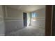 A drywall bedroom with a window allowing natural light and a doorway leading to another room at 2707 E Abe Truckle Ave, San Tan Valley, AZ 85140