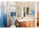 Well-lit bathroom with a wood vanity, white sink, toilet, and mirror, complemented by blue towels at 2838 E Vaughn Ct, Gilbert, AZ 85234