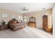 Spacious bedroom with a ceiling fan, natural light, neutral colored walls, and plush carpeting at 2838 E Vaughn Ct, Gilbert, AZ 85234