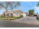 An impressive, ranch-style home showcasing a long driveway, 3-car garage, and lush green lawn at 2838 E Vaughn Ct, Gilbert, AZ 85234