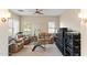 Cozy living room with leather furniture, a ceiling fan, and multiple windows offering natural light and views at 2838 E Vaughn Ct, Gilbert, AZ 85234