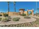 Elegant entrance to Seville Golf & Country Club with stone pillars, lush landscaping, and clear blue sky at 3080 E Palmdale Ln, Gilbert, AZ 85298