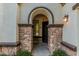 An inviting entryway with stone accents, an arched entryway, and warm lighting at 3080 E Palmdale Ln, Gilbert, AZ 85298