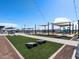 Community area featuring shaded picnic tables, benches, cornhole, and a playground under a clear blue sky at 3520 E Audrey Dr, San Tan Valley, AZ 85143