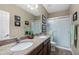 Bathroom featuring double sinks, granite countertops, and a glass-enclosed shower at 398 W Honey Locust Ave, San Tan Valley, AZ 85140