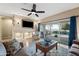 Bright living room with a ceiling fan, a TV set above a mantle, and sliding glass doors to the patio at 398 W Honey Locust Ave, San Tan Valley, AZ 85140