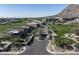 Aerial view of a gated community showcasing modern architecture, lush landscaping, a golf course, and mountain views at 5000 N Camelback Ridge Rd # 410, Scottsdale, AZ 85251