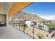 Expansive balcony view showcasing modern architecture, desert landscaping, and a luxurious pool area against a backdrop of hills at 5000 N Camelback Ridge Rd # 410, Scottsdale, AZ 85251