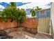 Charming backyard featuring a brick wall, lush tree with fruit, and a quaint patio area at 510 N Alma School Rd # 266, Mesa, AZ 85201