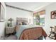 Inviting bedroom with stained-glass window art and floral accent wall, creating a cozy space at 5440 W Voltaire Dr, Glendale, AZ 85304