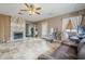 Open living area with a decorative fireplace, ceiling fan, tile flooring, and natural light at 6433 W Beverly Ln, Glendale, AZ 85306