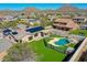 Aerial view of a home's backyard featuring a private pool, landscaped yard, and solar panels on the roof at 6603 W Via Dona Rd, Phoenix, AZ 85083