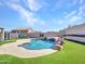 The backyard showcases a pool with rock waterfall, surrounded by synthetic turf for low-maintenance relaxation at 6603 W Via Dona Rd, Phoenix, AZ 85083