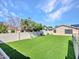 The backyard offers synthetic grass and a block wall for privacy and an area for outdoor enjoyment at 6603 W Via Dona Rd, Phoenix, AZ 85083