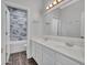 Bright bathroom with double sink vanity and a shower/tub featuring stylish marble-patterned tile surround at 6603 W Via Dona Rd, Phoenix, AZ 85083