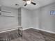 Neutral bedroom with wood-look tile, ceiling fan and decorative shelves at 6603 W Via Dona Rd, Phoenix, AZ 85083