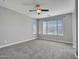 Bright bedroom with soft carpet, neutral walls, two windows, and a ceiling fan at 6603 W Via Dona Rd, Phoenix, AZ 85083