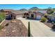 Inviting single-story home with a two-car garage, desert landscaping and a concrete driveway nestled among the mountains at 6603 W Via Dona Rd, Phoenix, AZ 85083