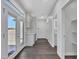 Hallway with light grey walls and wood look floors leads to a bathroom with an illuminated mirror and a door to the back yard at 6603 W Via Dona Rd, Phoenix, AZ 85083