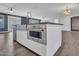 Modern kitchen island with stainless steel appliances and a sleek, white countertop in an open layout at 6603 W Via Dona Rd, Phoenix, AZ 85083