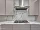 Modern kitchen with stainless steel range hood and marble countertops, showcasing a stylish cooking space at 6603 W Via Dona Rd, Phoenix, AZ 85083