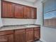 Well-equipped laundry room with dark wood cabinets and sink at 6603 W Via Dona Rd, Phoenix, AZ 85083