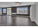 Spacious living room with dark wood-look tile floors and ample natural light from large windows at 6603 W Via Dona Rd, Phoenix, AZ 85083