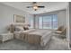 Serene main bedroom featuring a plush bed, soft lighting, and a large window overlooking the beautiful outdoors at 6603 W Via Dona Rd, Phoenix, AZ 85083