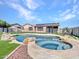 Backyard with a uniquely shaped pool, a spa, and surrounding rock features perfect for relaxing and entertaining at 6603 W Via Dona Rd, Phoenix, AZ 85083