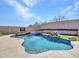 Beautiful pool with a rock waterfall and surrounded by artificial turf at 6603 W Via Dona Rd, Phoenix, AZ 85083