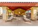 Poolside covered seating area with ceiling fan, lounge chairs, and cushioned couches at 7008 E Gold Dust Ave # 236, Scottsdale, AZ 85253