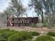 Decorative Aloravita community sign with lush greenery and desert plants in the foreground at 7688 W Saddlehorn Rd, Peoria, AZ 85383