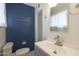 This bathroom has a white sink, light fixtures, towel rack, toilet, and dark blue accent wall at 808 W 9Th St, Tempe, AZ 85281