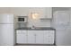 Functional kitchenette featuring appliances, white cabinets, and granite countertops at 808 W 9Th St, Tempe, AZ 85281