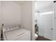 Well-lit laundry area adjacent to modern bathroom with white-tiled shower and dark wood floors at 808 W 9Th St, Tempe, AZ 85281