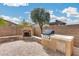 Backyard with pavers, fireplace, grill, and mature trees at 9165 W Mine Trl, Peoria, AZ 85383