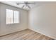 Bedroom with wood-look flooring, ceiling fan, and window providing natural light at 9165 W Mine Trl, Peoria, AZ 85383