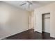 Bedroom with dark wood-look flooring, ceiling fan, closet and ensuite door at 9165 W Mine Trl, Peoria, AZ 85383