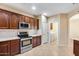 Kitchen area featuring modern stainless steel appliances and ample cabinet space with laundry area view at 9165 W Mine Trl, Peoria, AZ 85383