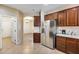 View of the kitchen featuring stainless steel refrigerator, wood cabinets and white backsplash at 9165 W Mine Trl, Peoria, AZ 85383