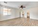 Spacious main bedroom featuring wood-look flooring, ceiling fan, closet and ensuite door at 9165 W Mine Trl, Peoria, AZ 85383