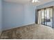 Bright bedroom with soft blue walls and a sliding glass door leading to a private balcony at 9455 E Raintree Dr # 2032, Scottsdale, AZ 85260