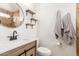 Bathroom featuring a modern sink, round mirror, and decorative shelves at 1018 E Tonto Ln, Phoenix, AZ 85024