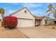 Exterior view of a charming home showcasing a well-maintained garage and vibrant bougainvillea bush at 1018 E Tonto Ln, Phoenix, AZ 85024